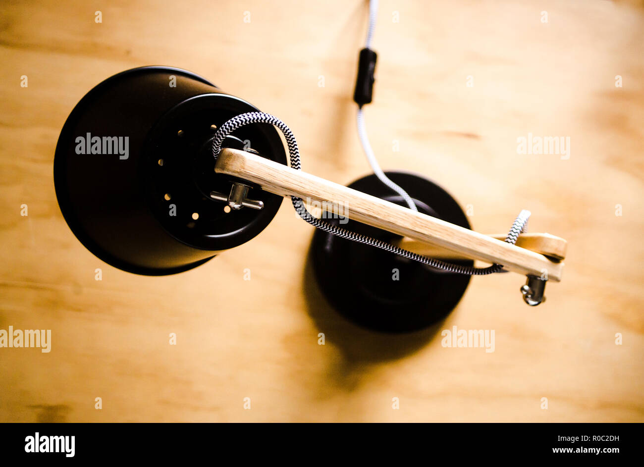 Black and wood desk lamp from above faces down on wooden table Stock Photo