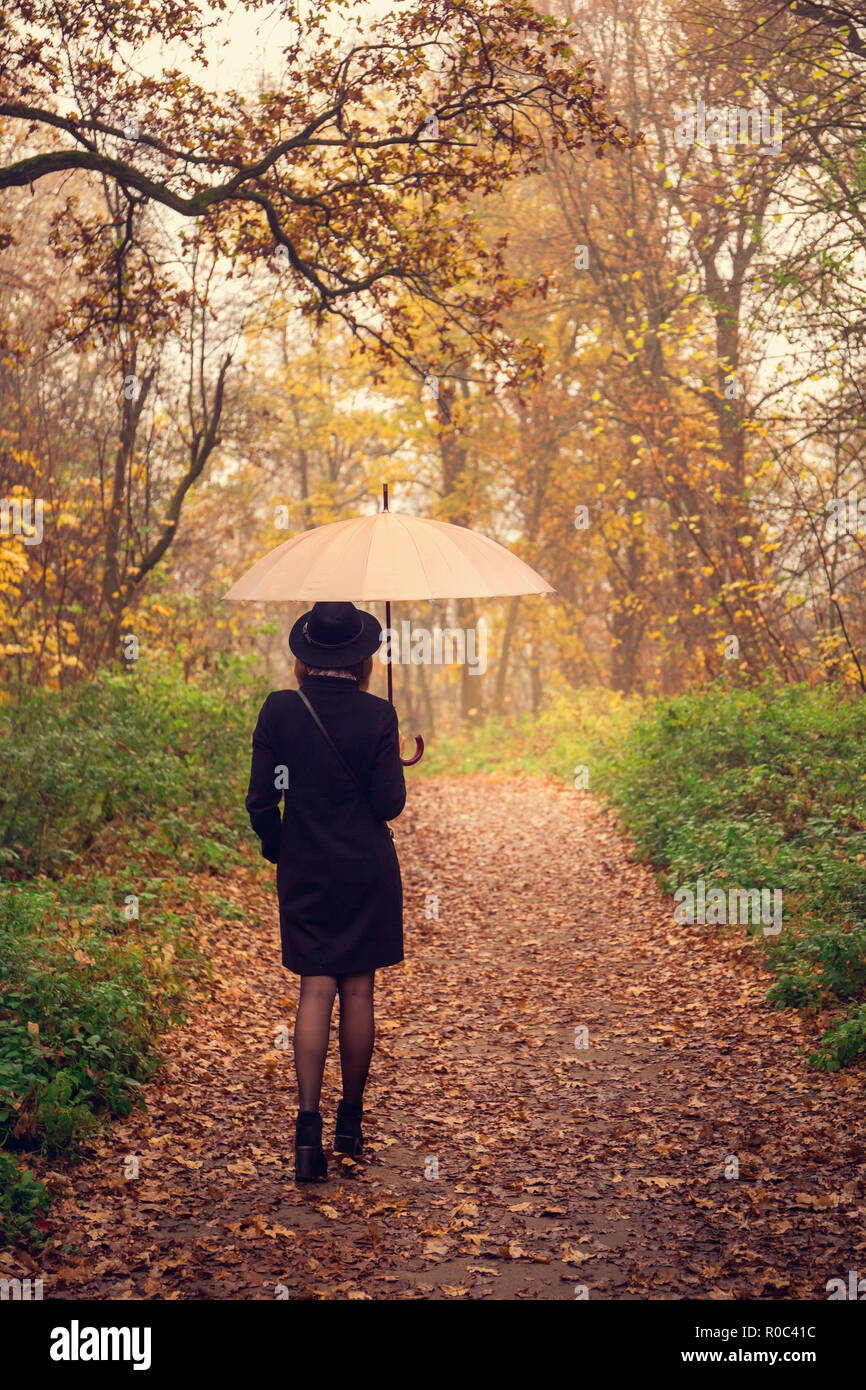 woman walking under an umbrella Stock Photo - Alamy