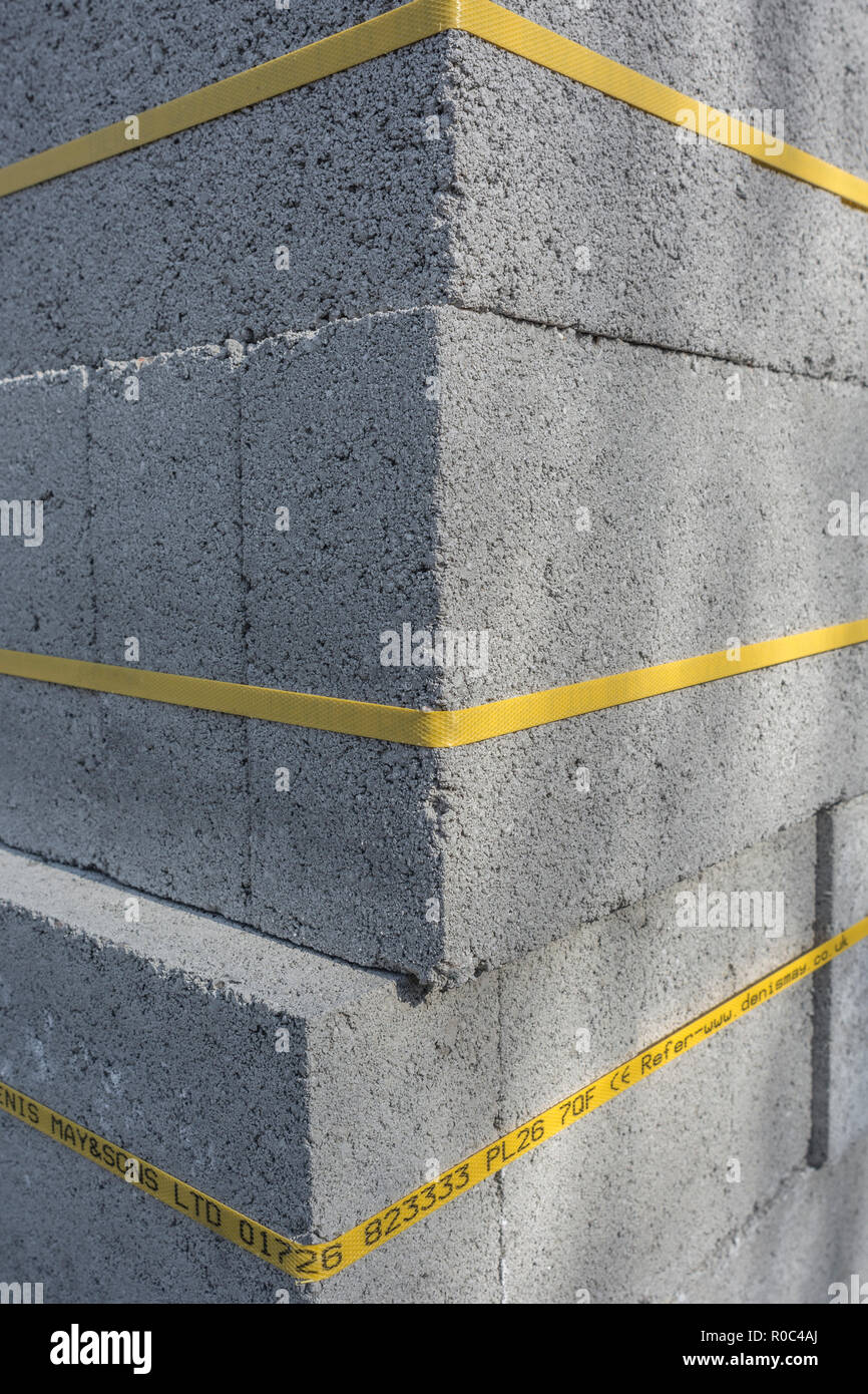 Stack of cinder blocks on new-build housing site. Supplier'sdetails on bottom yellow band, hence RM - but guess could be erased where required. Stock Photo