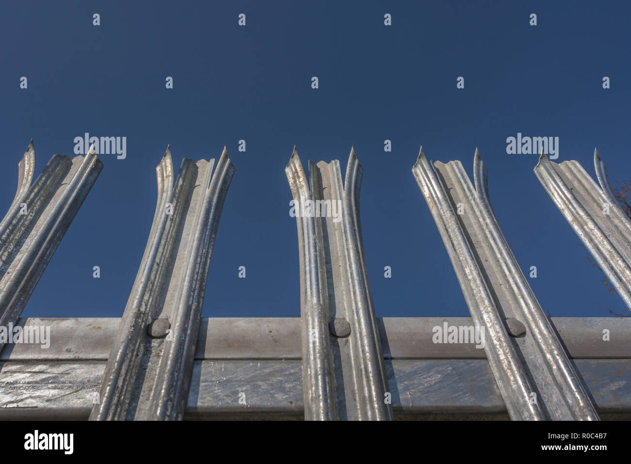 Robust galvanised anticlimb steel fence metaphor 'Keep Out', concept of barriers and US