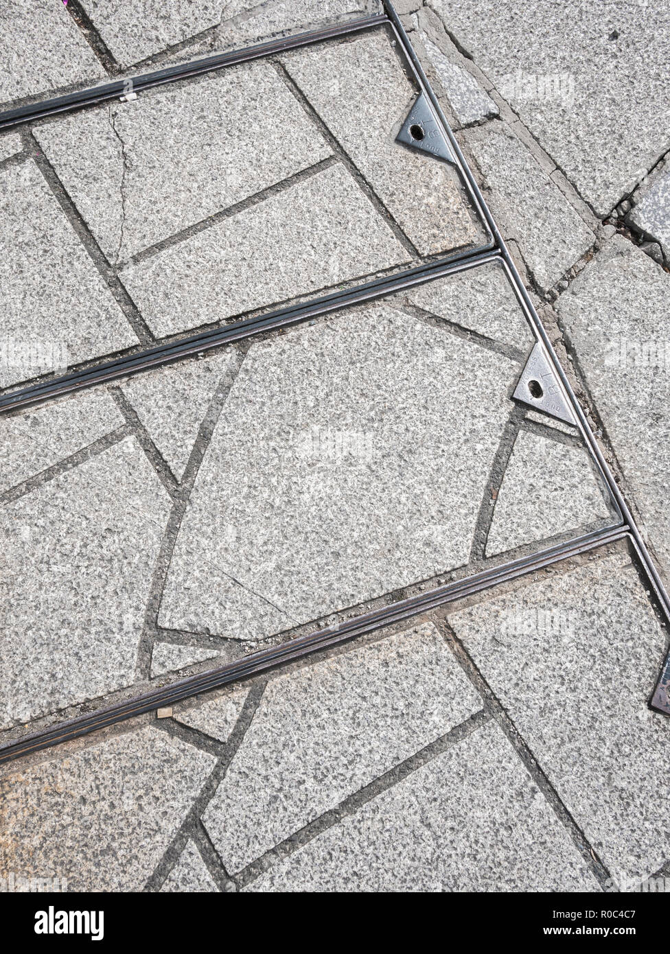 Section of paving in St. Austell, Cornwall, where slabs have been cut into sections to fit awkward angles. Stock Photo