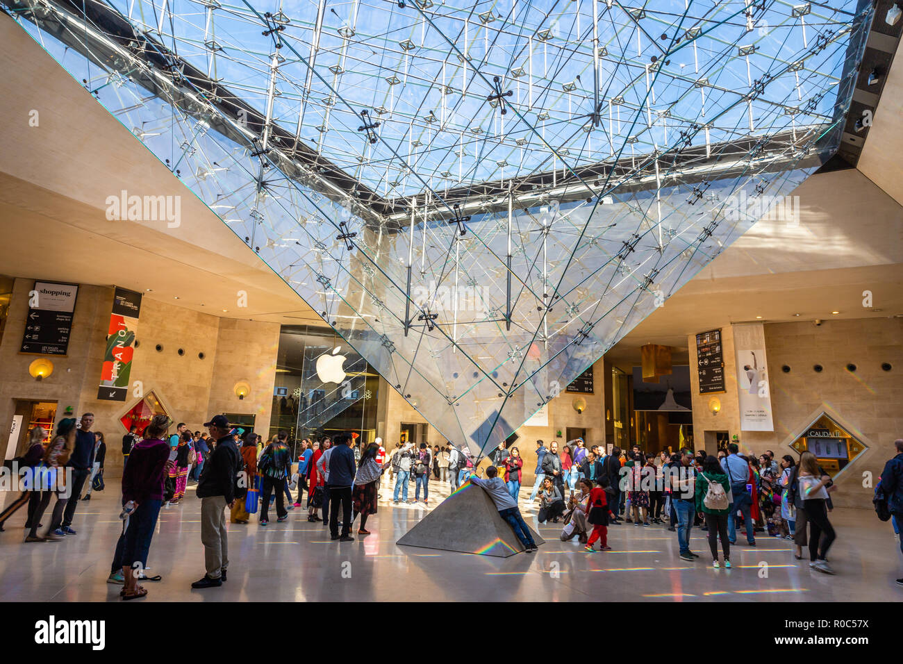 Paris, France - September 30, 2018: Walking tourists around reversal glass and metal pyramid inside shopping mall underground of Louvre pyramid. Stock Photo