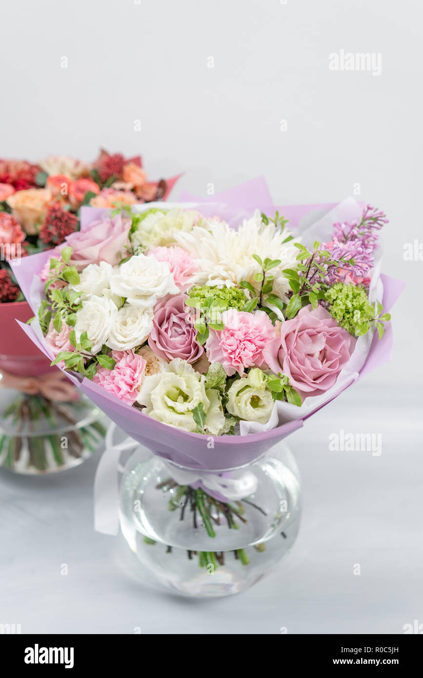 European floral shop. Two Bouquet Mixed beautiful flowers on wooden gray table. Nice garden flowers in the arrangement , the work of a professional florist. Stock Photo