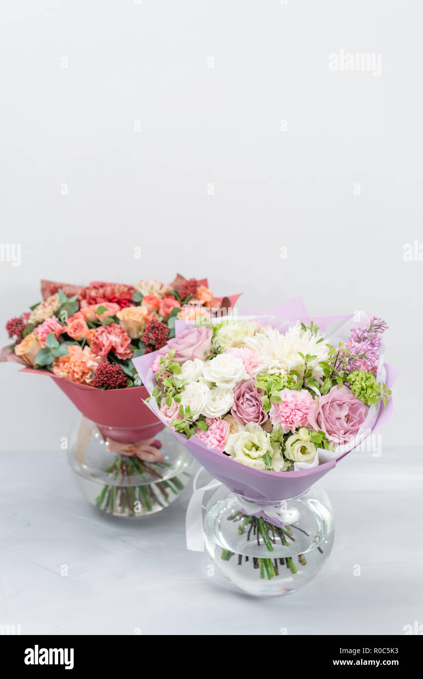 European floral shop. Two Bouquet Mixed beautiful flowers on wooden gray table. Nice garden flowers in the arrangement , the work of a professional florist. Stock Photo