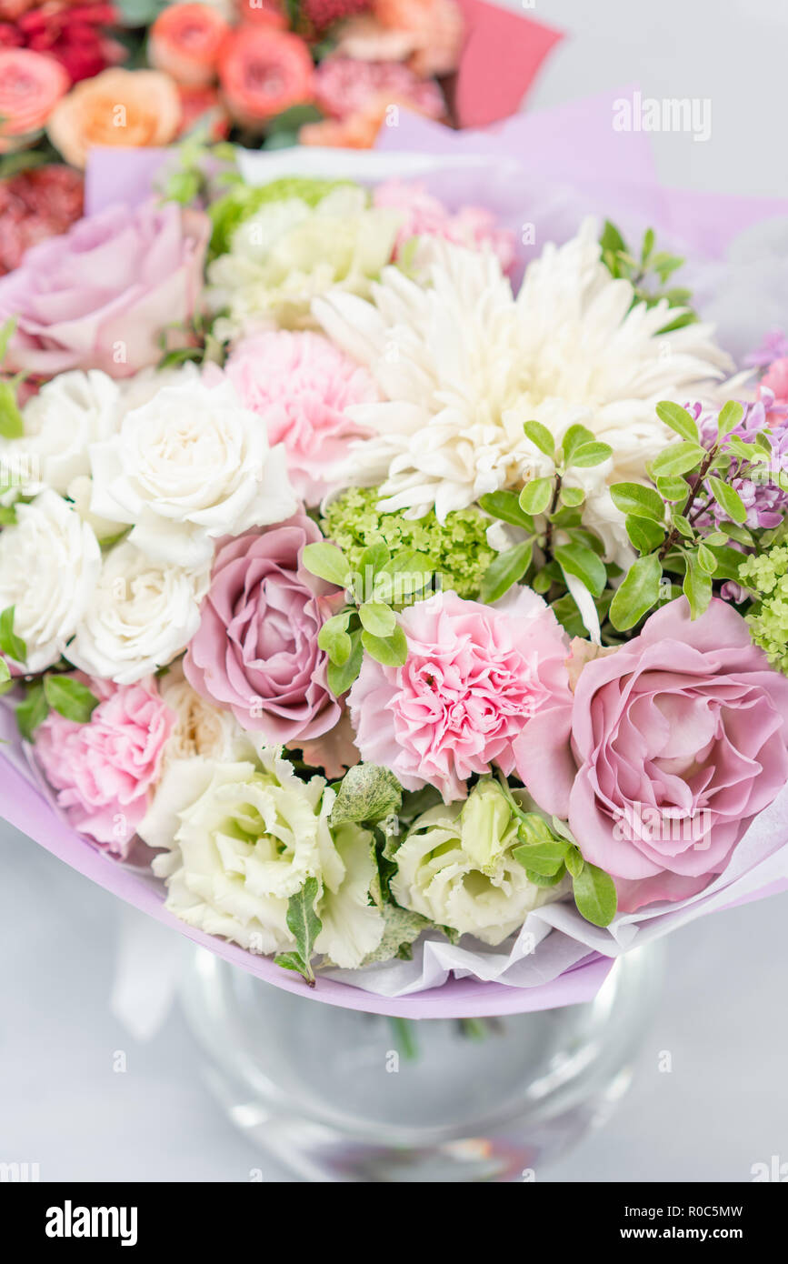 European floral shop. Bouquet Mixed beautiful flowers on wooden gray table. Nice garden flowers in the arrangement , the work of a professional florist. Stock Photo