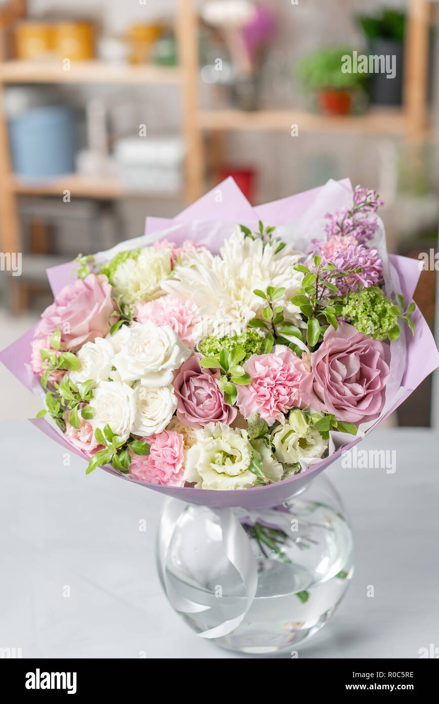 European floral shop. Bouquet Mixed beautiful flowers on wooden gray table. Nice garden flowers in the arrangement , the work of a professional florist. Stock Photo