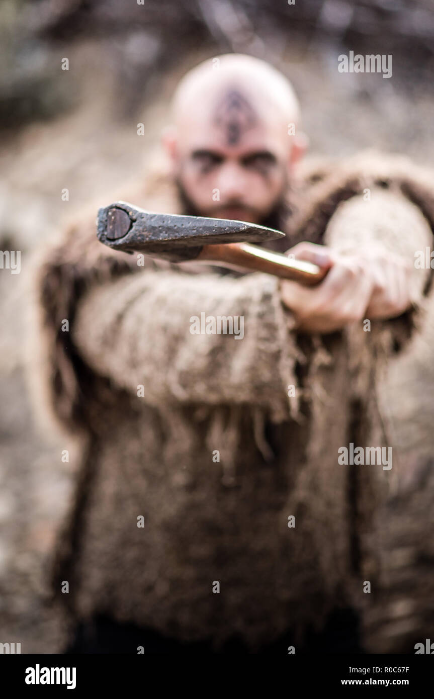 A male viking inspired character in the mountains. Model wearing real fur and carrying an axe Stock Photo