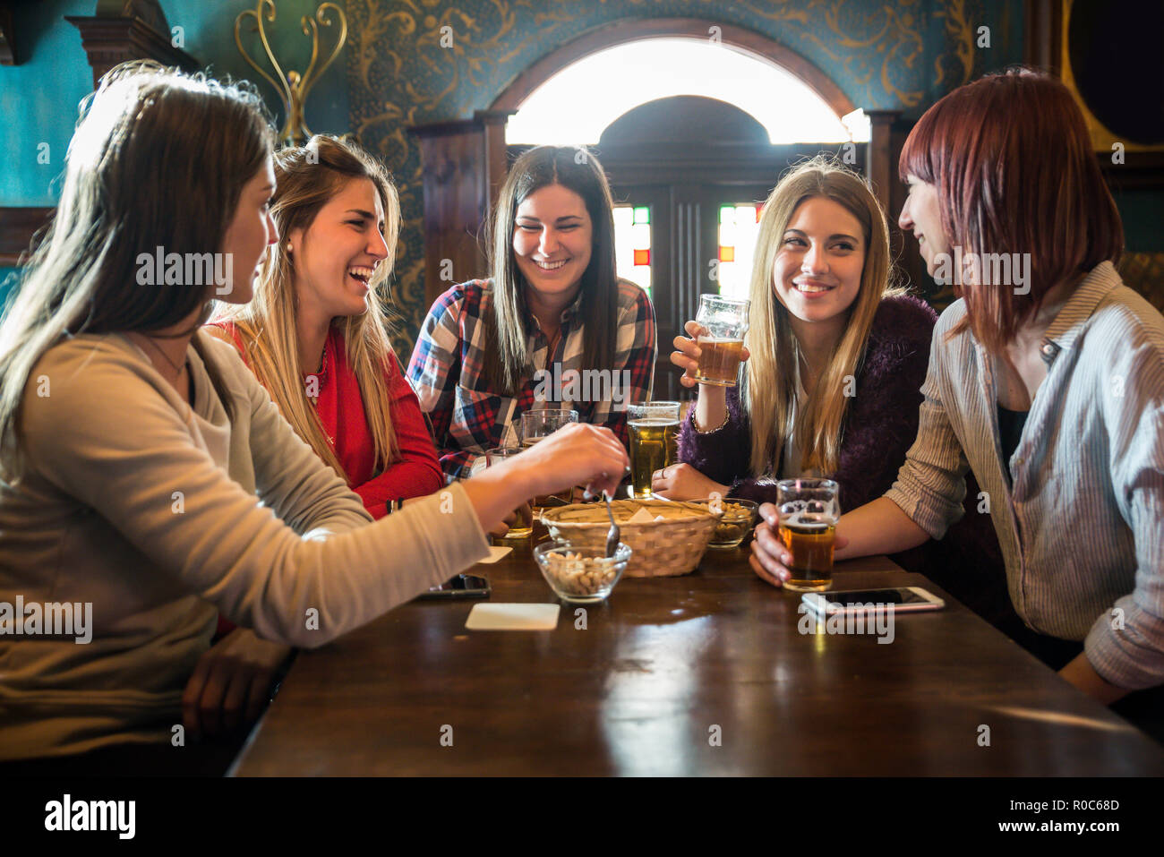 Group of happy friends having party in a bar - Young people drinking ...