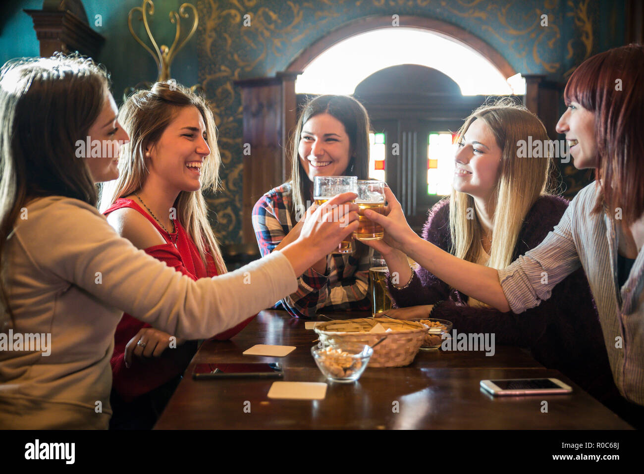 Group of happy friends having party in a bar - Young people drinking ...