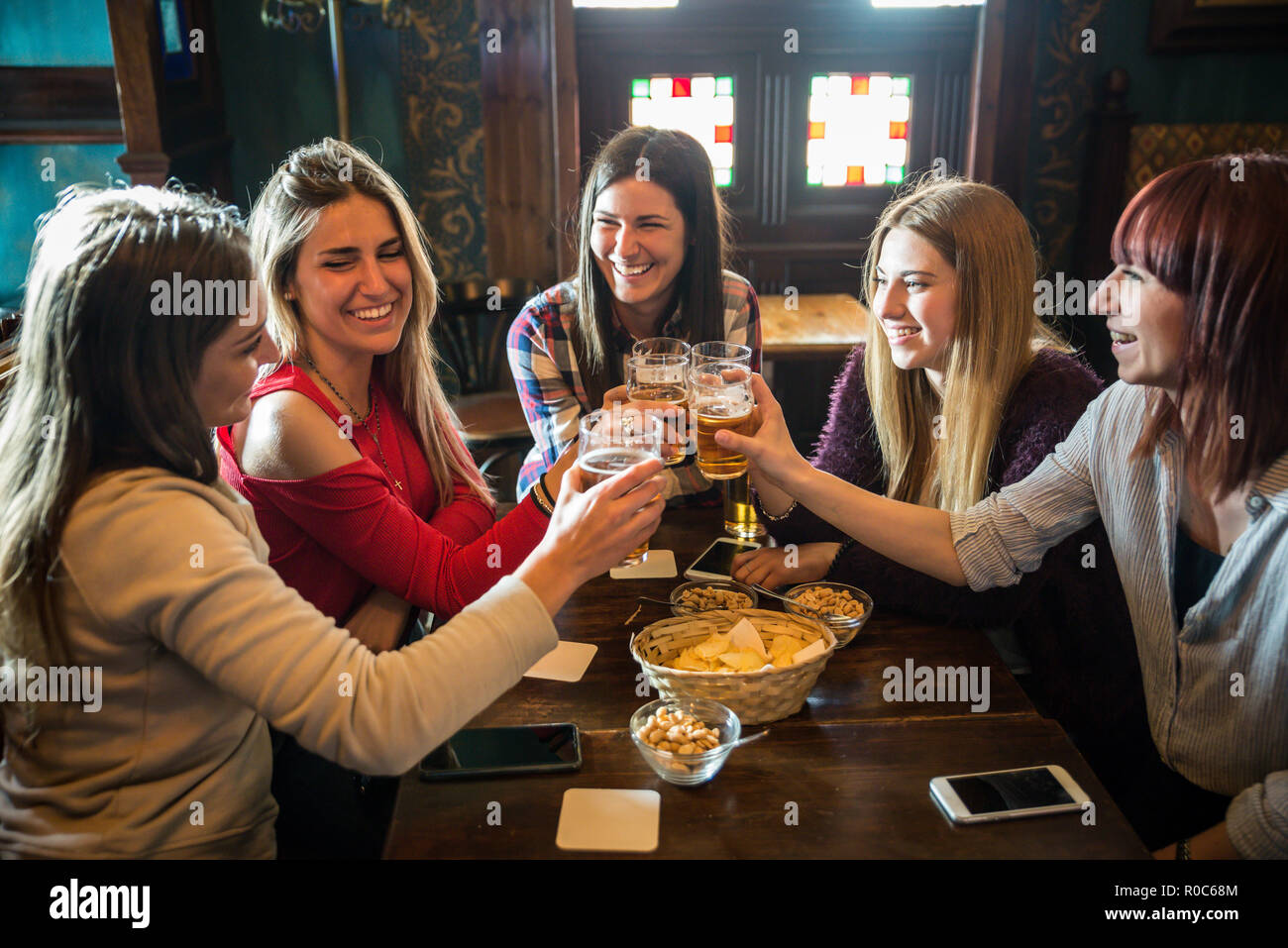 Group of happy friends having party in a bar - Young people drinking ...