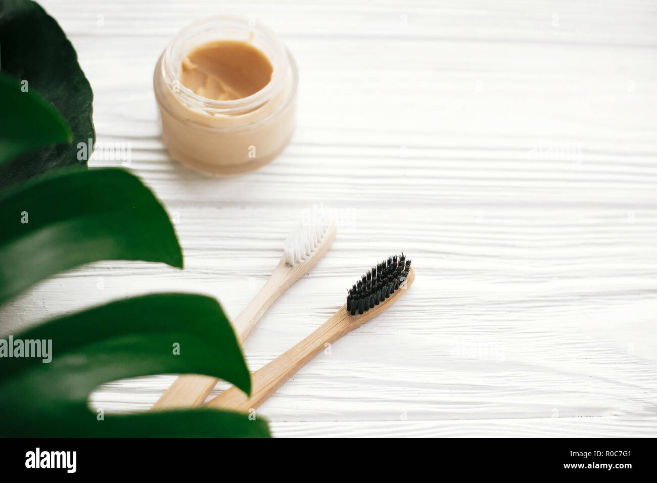 Natural eco friendly bamboo toothbrushes and toothpaste in glass on ...