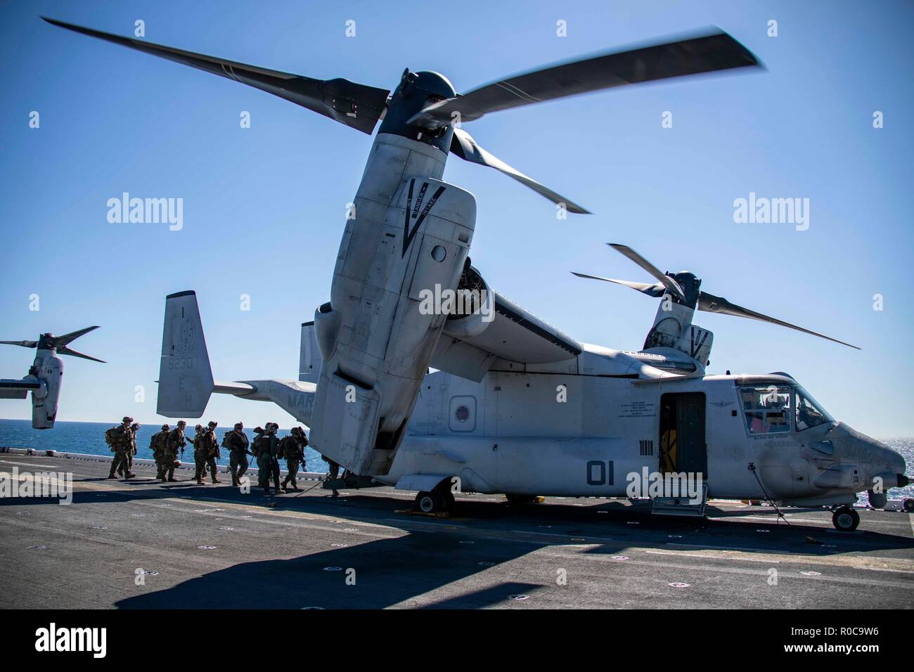 181029-N-KW492-0135 ATLANTIC OCEAN (Oct. 29, 2018) Marines assigned to the 22nd Marine Expeditionary Unit (MEU) embark an MV-22 Osprey on the flight deck of the Wasp-class amphibious assault ship USS Kearsarge (LHD3) during the Carrier Strike Group (CSG) 4 composite training unit exercise (COMPTUEX). COMPTUEX is the final pre-deployment exercise that certifies the combined Kearsarge Amphibious Ready Group's and 22nd MEU's abilities to conduct military operations at sea and project power ashore through joint planning and execution of challenging and realistic training scenarios. CSG 4 mentors,  Stock Photo