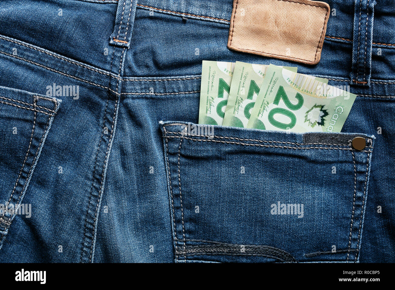 Twenty Canadian dollar CAD bills in the back pocket of a blue jean Stock Photo