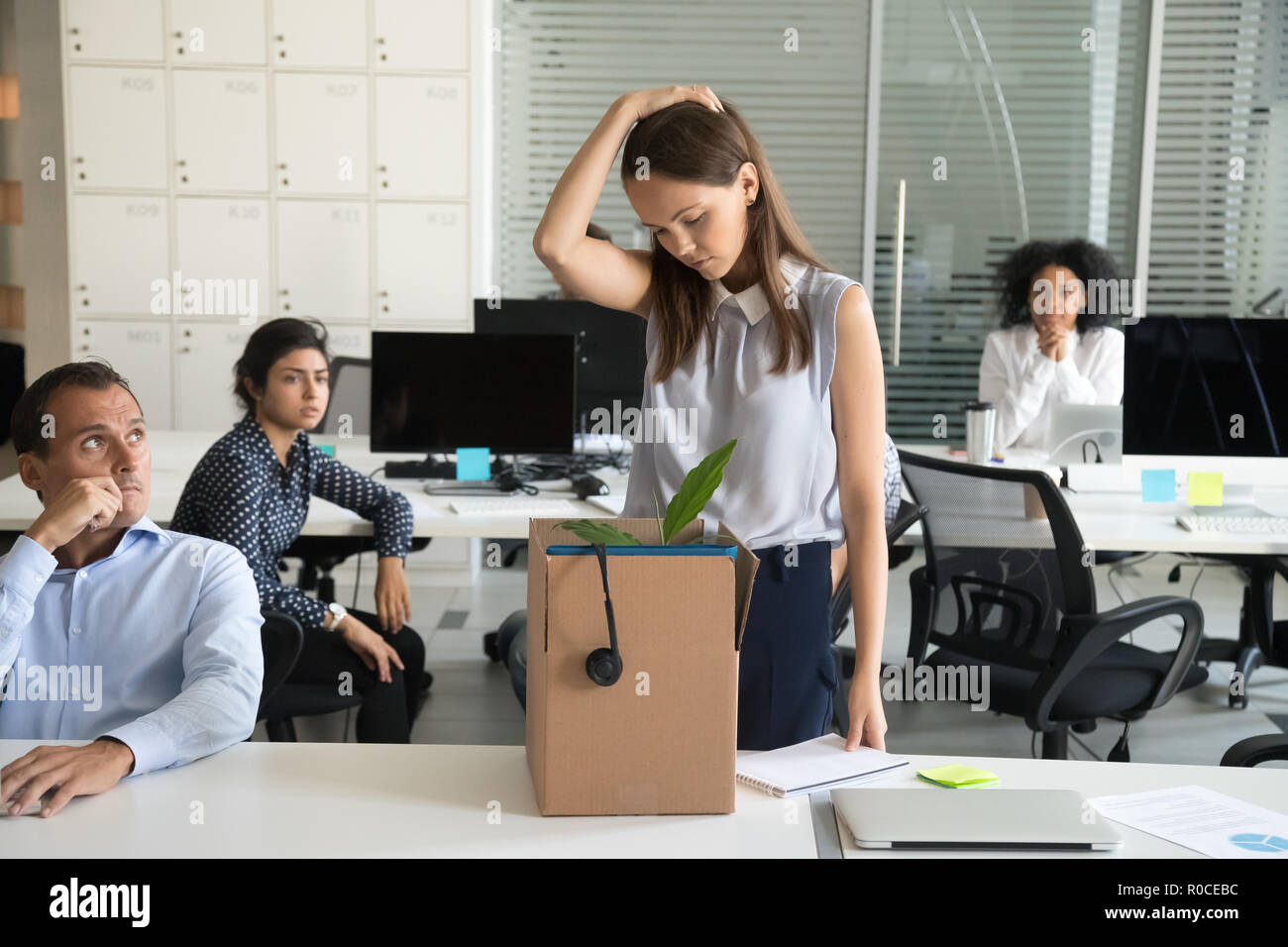 Upset female employee packing box getting fired from job  Stock Photo