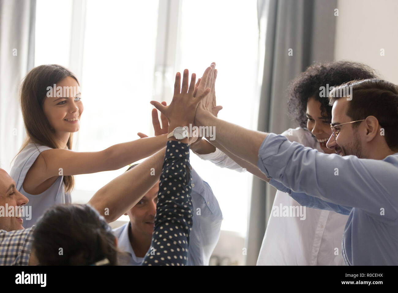 Excited diverse office team giving high five together celebratin Stock ...