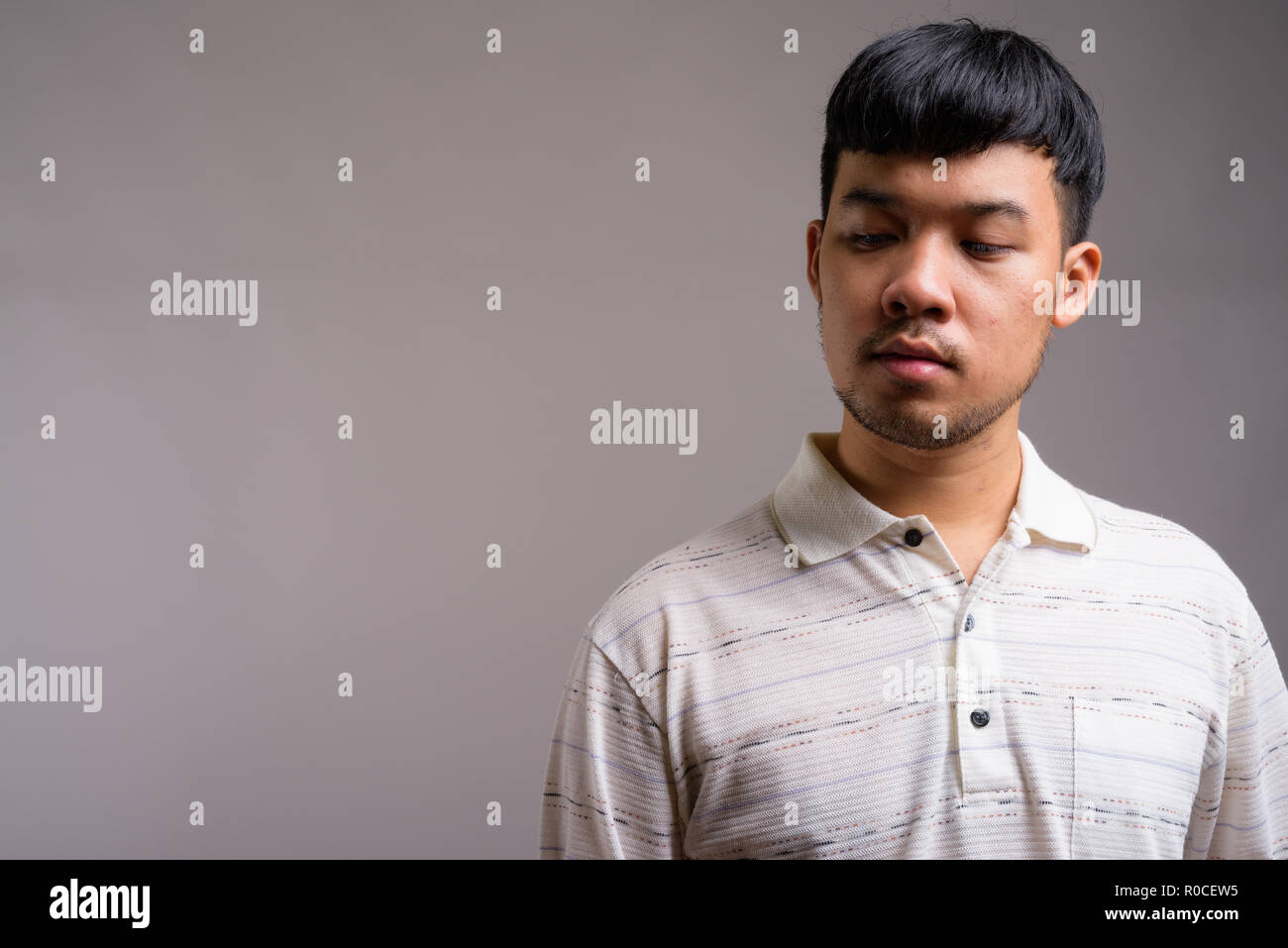 Portrait of young Asian man against gray background Stock Photo - Alamy