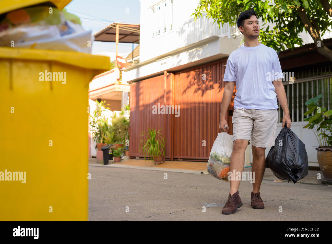 Young Asian man taking out the garbage at home  Stock Photo