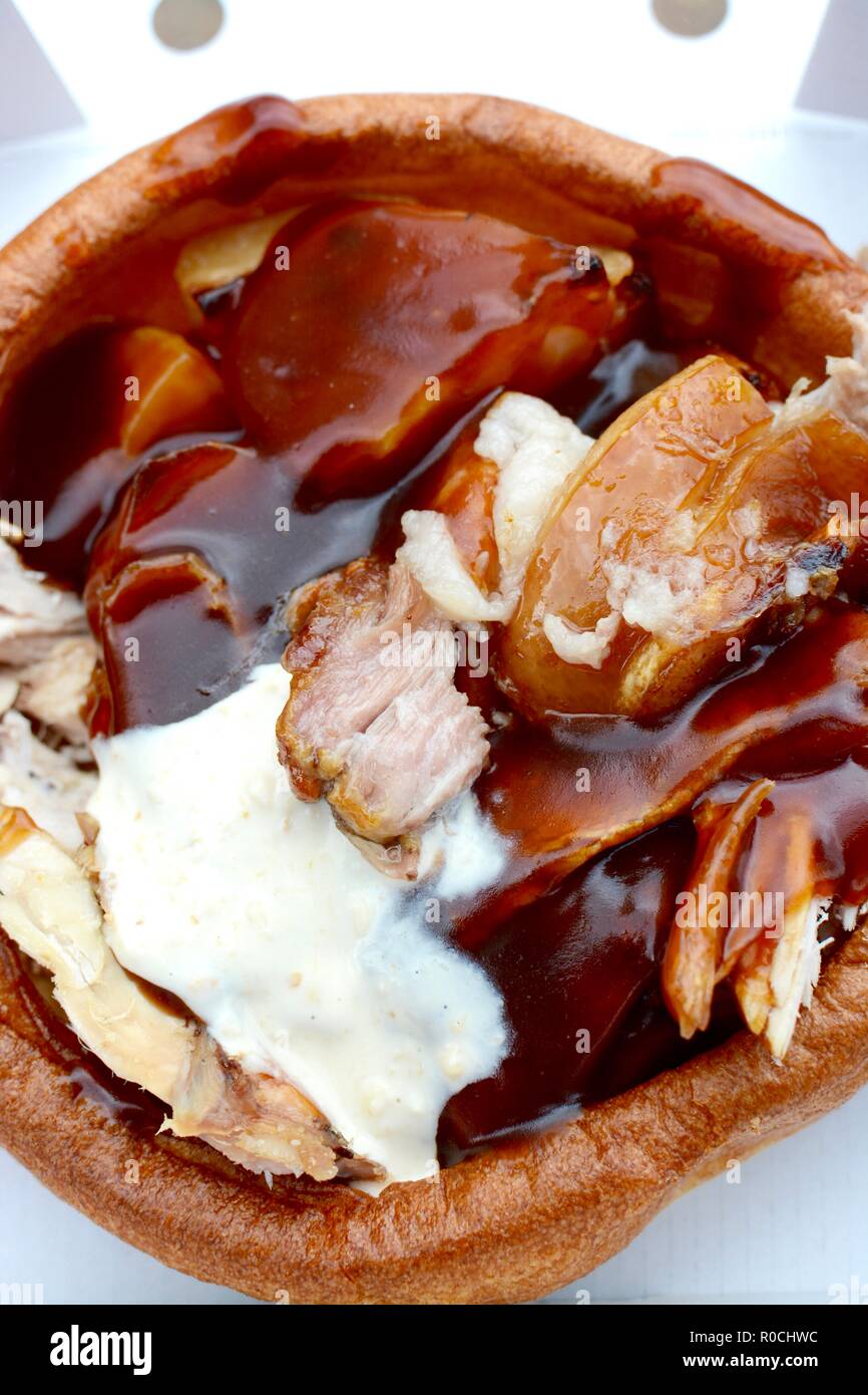 Takeaway roast dinner with mixed meats and gravy served in a giant Yorkshire pudding Stock Photo