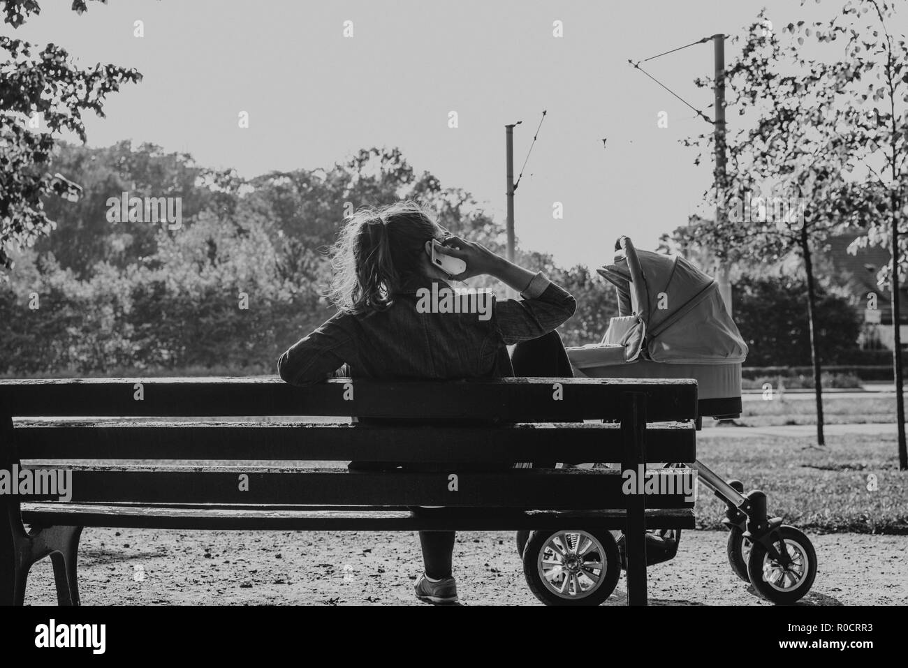 mother with baby and the phone on bench in the park Stock Photo - Alamy
