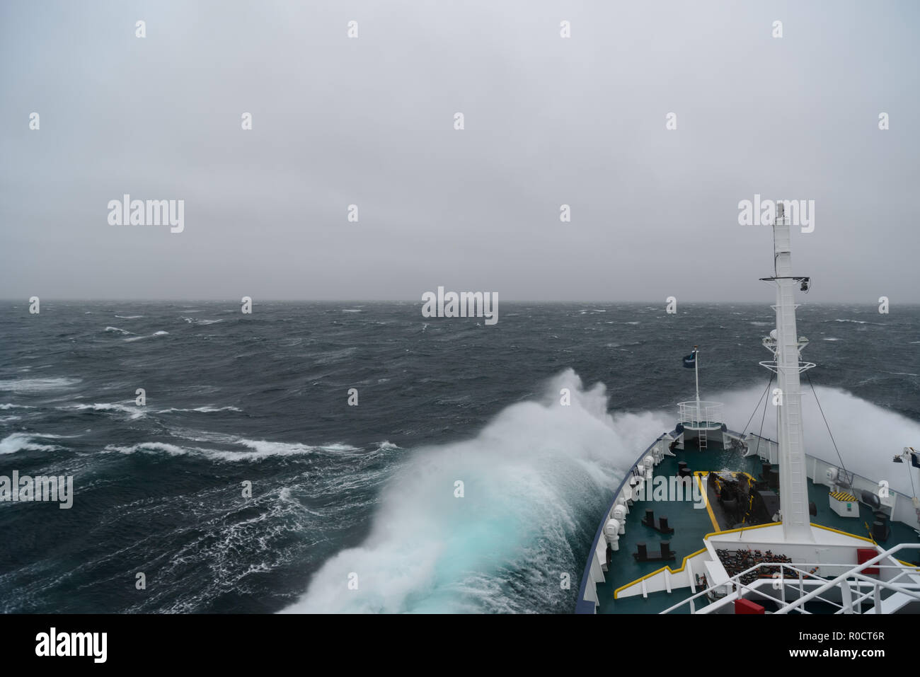 Ship cruising in storm and heavy seas crossing the Denmark Strait between Greenland and Iceland. Stock Photo