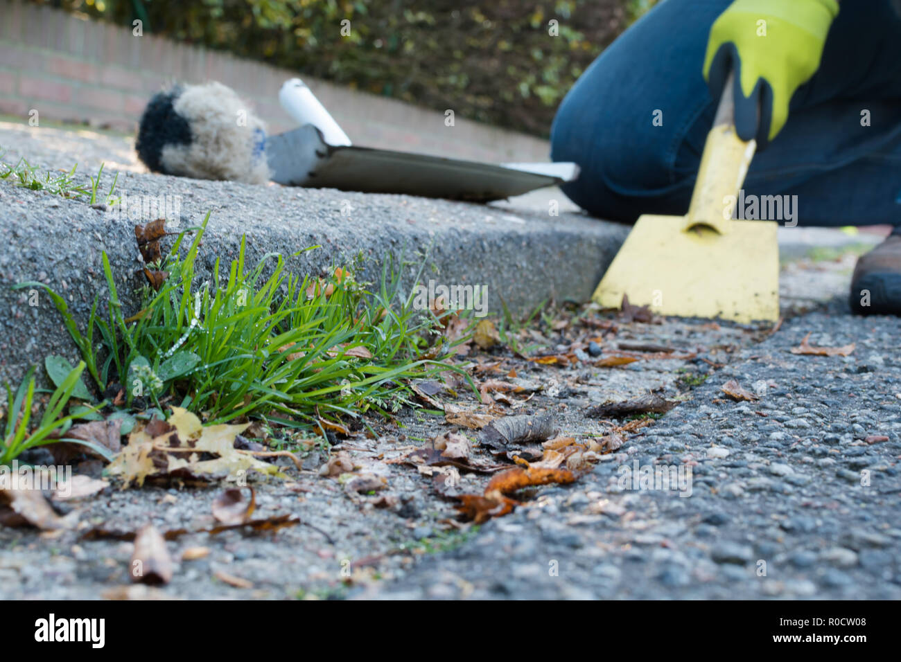 Man is cleaning the street gutter Stock Photo