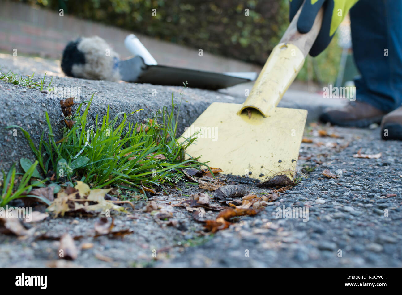 Man is cleaning the street gutter Stock Photo