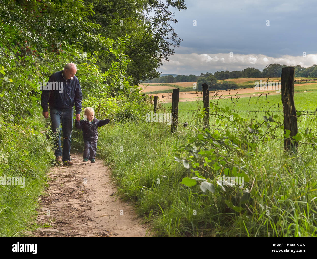 grandfather is walking with child on a walking track with family in nature Stock Photo