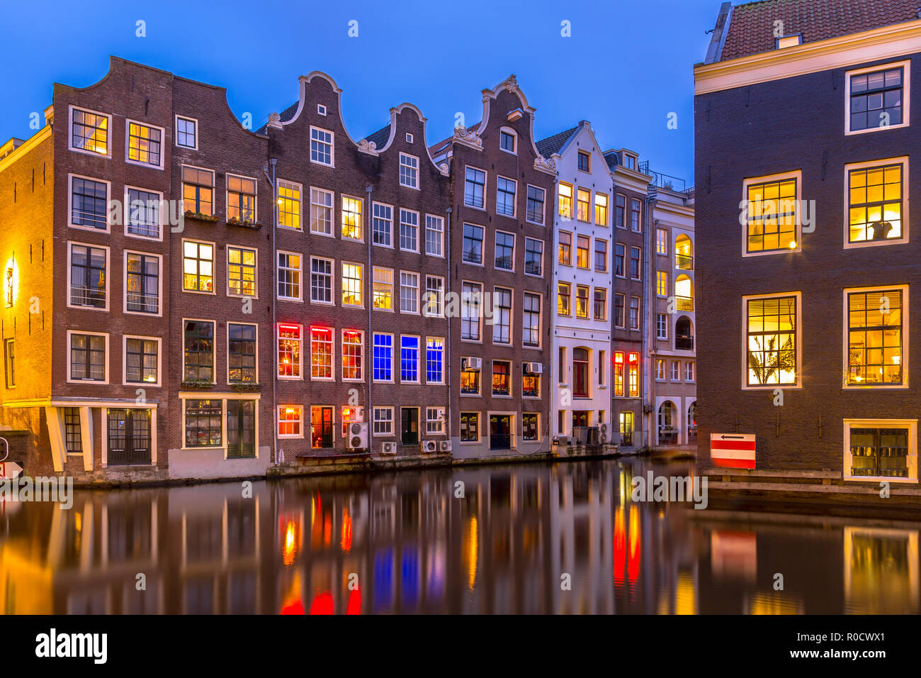 Nightscape of colorful traditional canal houses at night seen from the armbrug on the oudezijds voorburgwal in the UNESCO World Heritage site of Amste Stock Photo