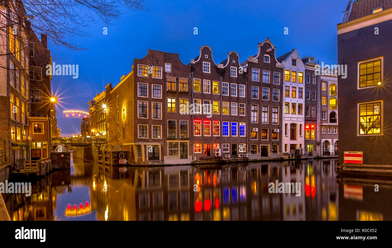 Traditional colorful canal houses at night seen from the Sint Olofsteeg on the Oudezijds Voorburgwal in the UNESCO World Heritage site of Amsterdam Stock Photo