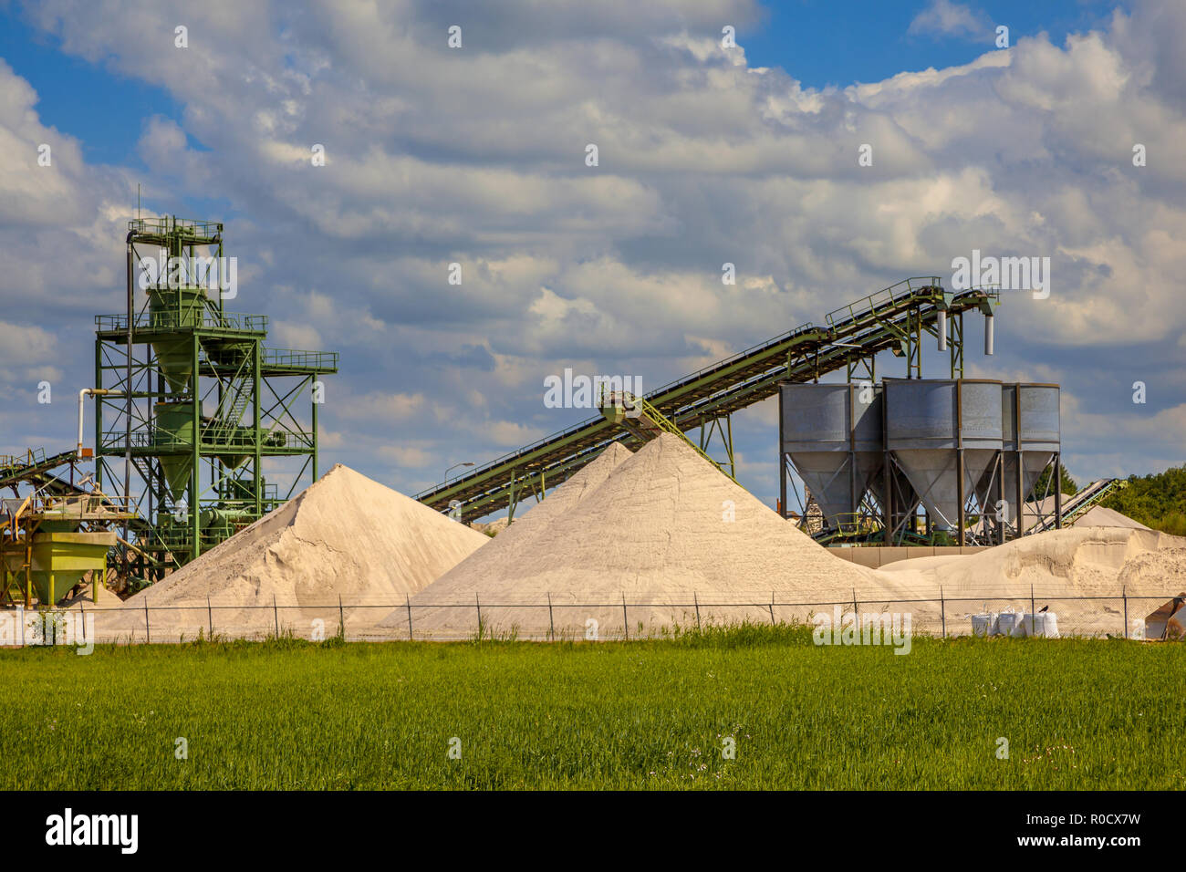 Industrial sand mining terminal with conveyer belts and silos on a clouded summer day Stock Photo