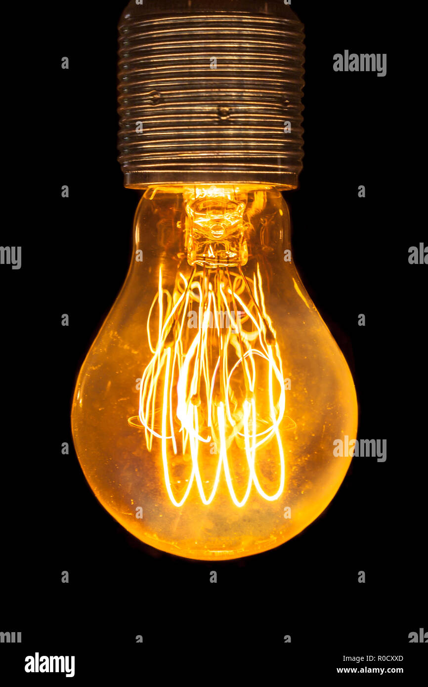 Vintage electric yellow light bulb glowing in the dark Stock Photo Alamy