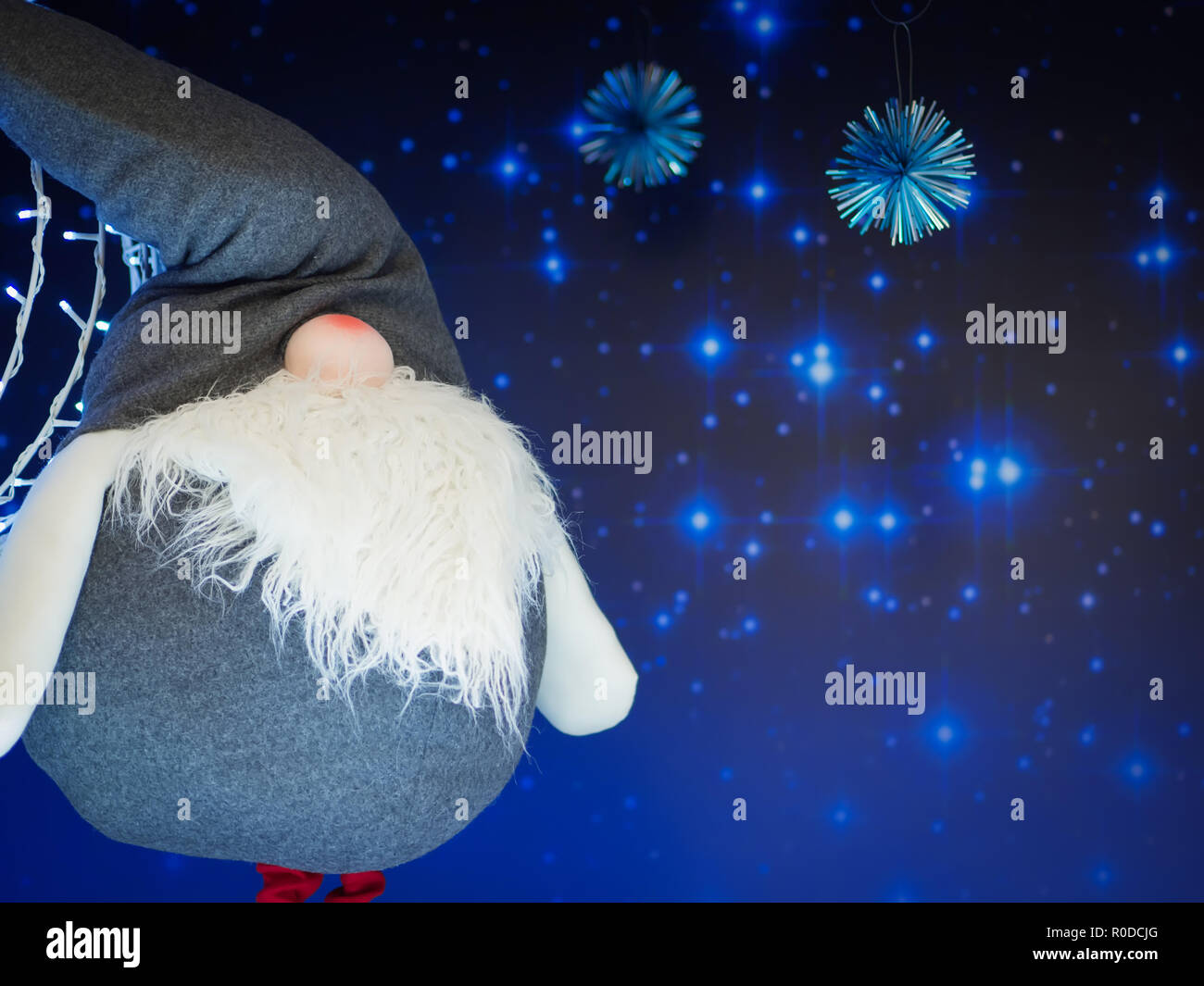 A soft elf toy standing against starry dark blue background. Christmas and New Year concept. Stock Photo