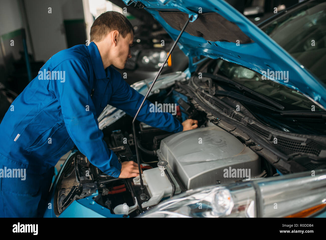 Mechanic repairs car engine, motor diagnostic. Car with opened hood