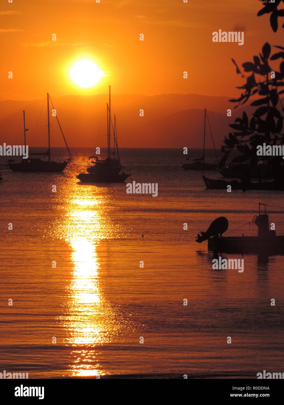 boats over sunset in the beach Stock Photo - Alamy