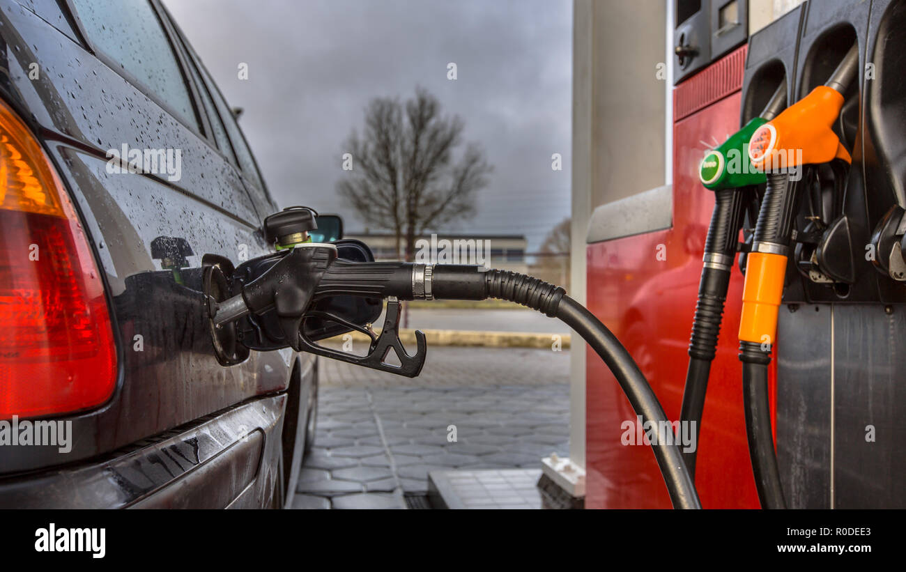 Gas station car refueling close up on a rainy februari day with dark colors in the Netherlands Stock Photo