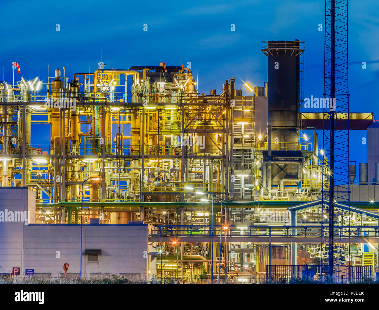 Framework in a heavy Chemical Industrial plant  with mazework of tubes and pipes during twilight Stock Photo