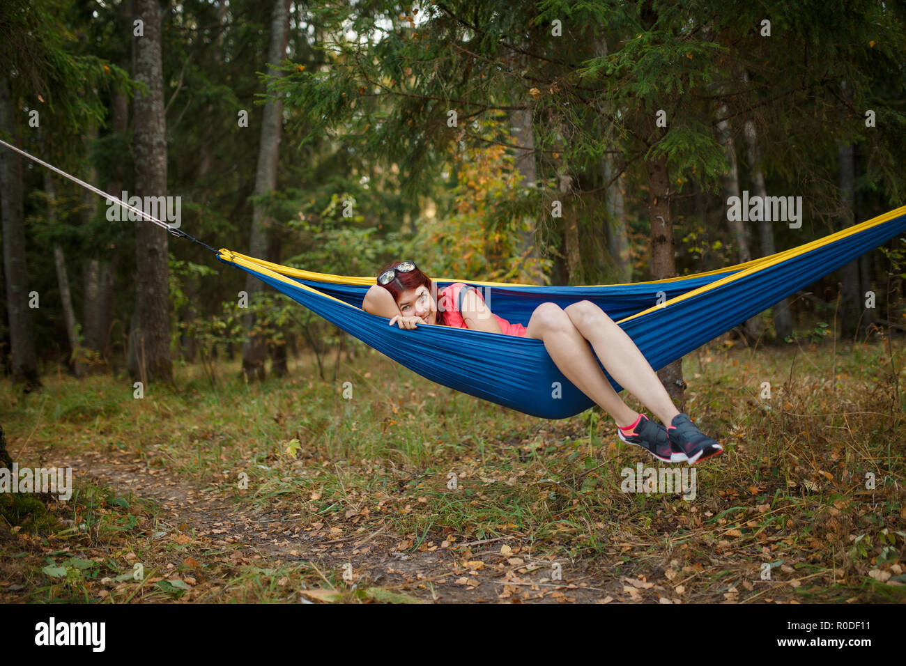 Photo of young woman lying in hammock in woods Stock Photo
