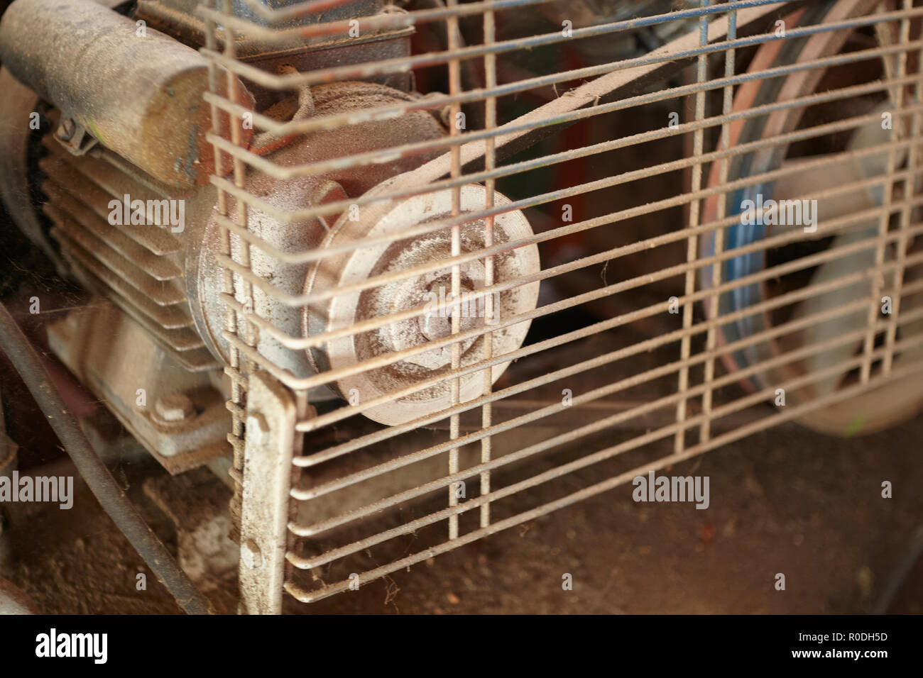 Detail of a pulley of a belt transmission protected by a grating that