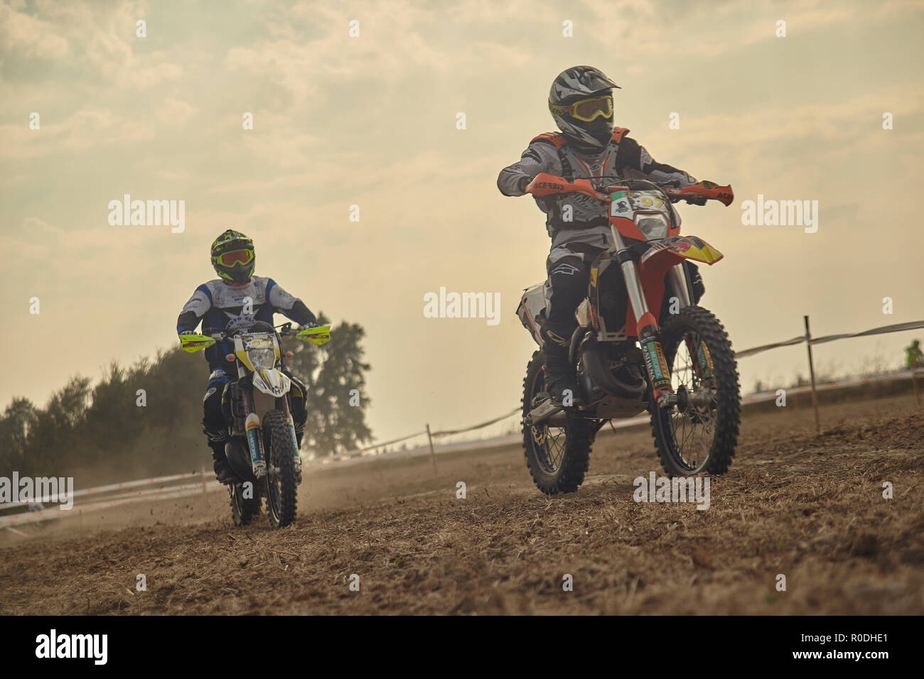 Pair of enduro riders whizzing along the race track, chasing and ...