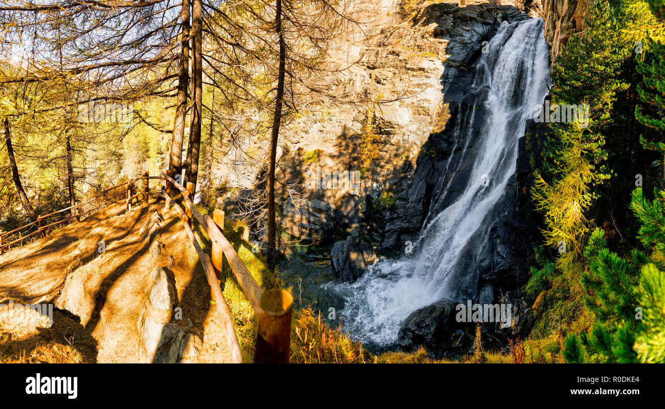 Wonderful waterfall in the forest in the mountains during the autumn season with light and shadows in the undergrowth Stock Photo