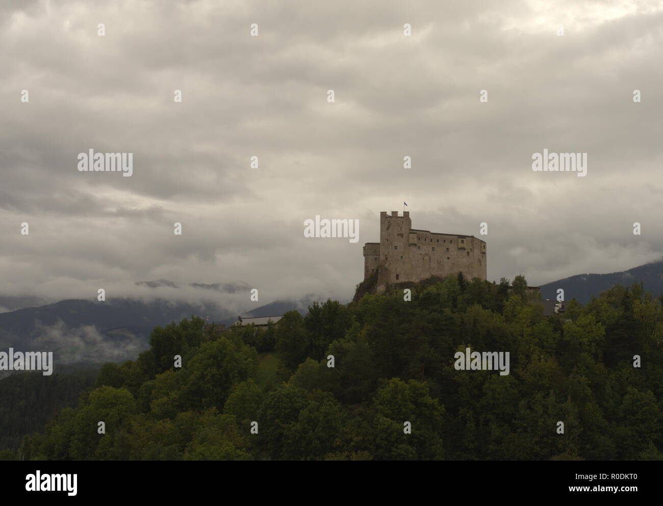 View on an old fortress in a mountain landscape with forest and meadows Stock Photo