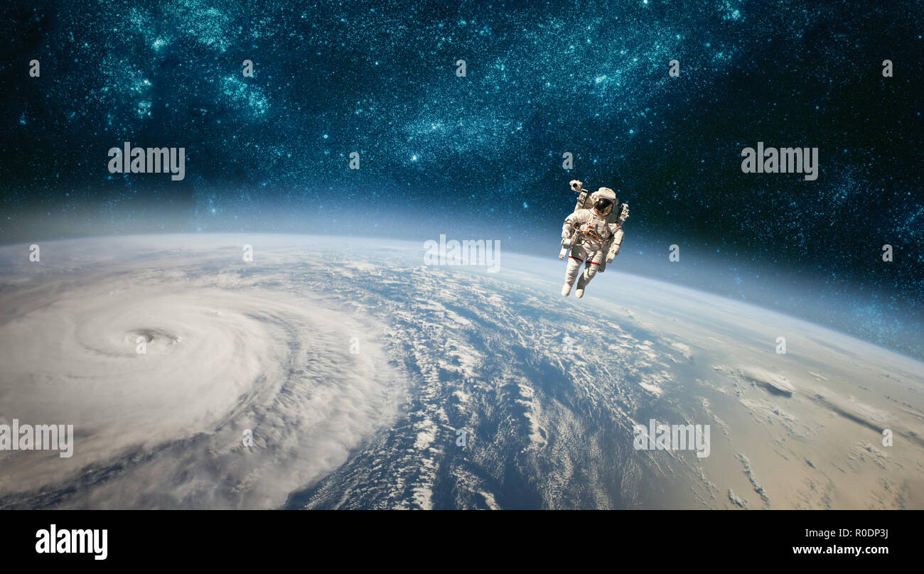 Astronaut in outer space against the backdrop of the planet earth. Typhoon over planet Earth. Elements of this image furnished by NASA. Stock Photo