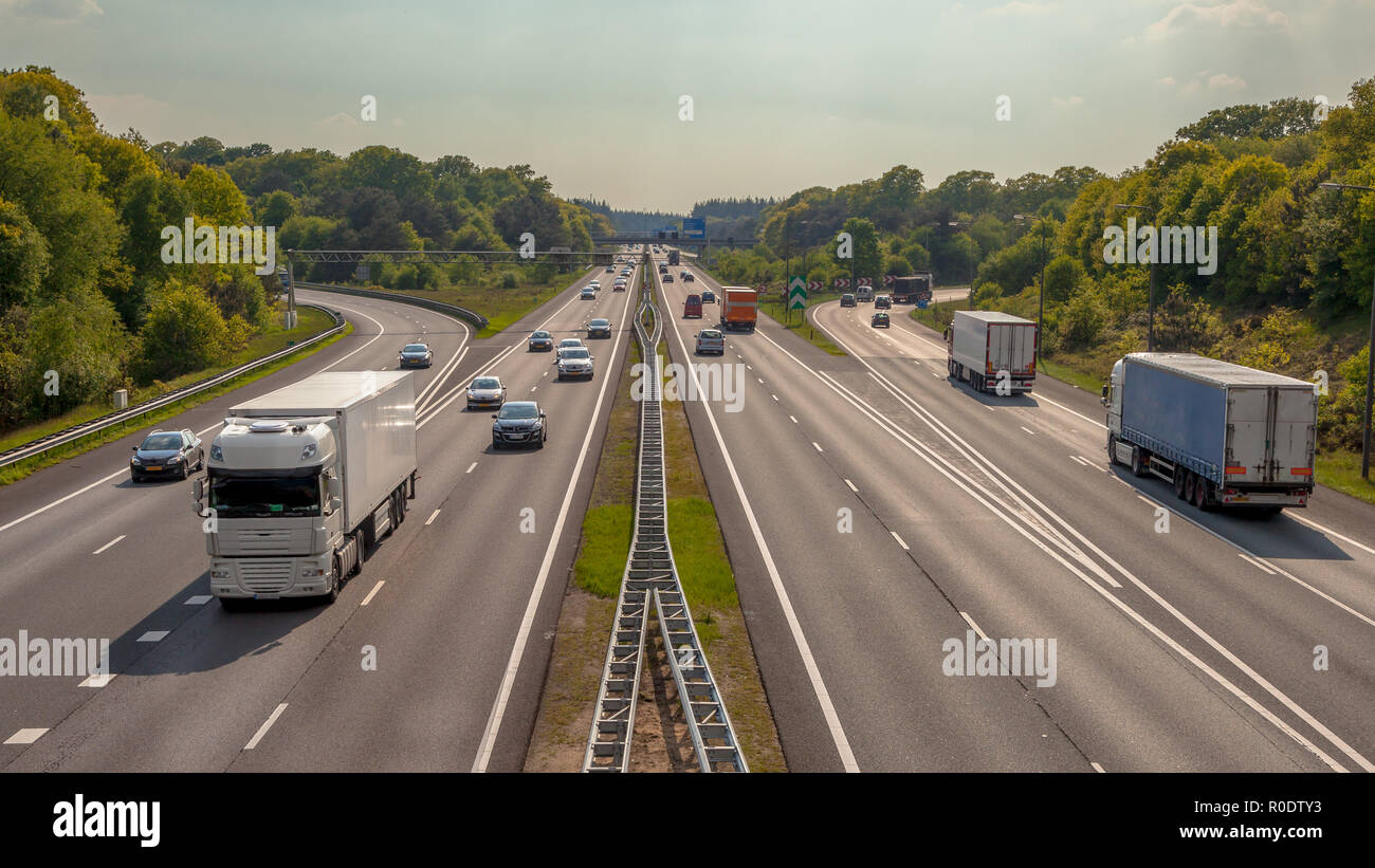 Right hand side Evening Traffic on the A12 Motorway through the Veluwe forest. One of the Bussiest highways in the Netherlands Stock Photo