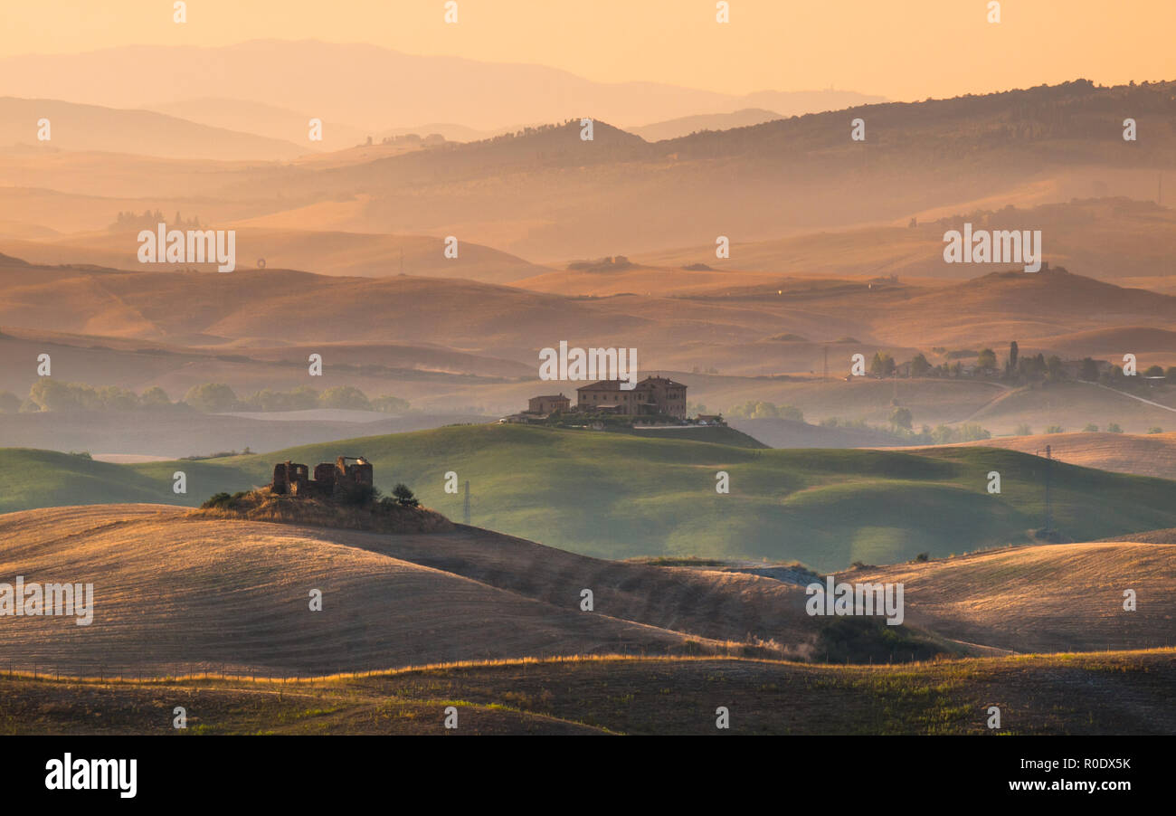 Sunrise over Farms in Hilly Countryside in Tuscany, Italy Stock Photo