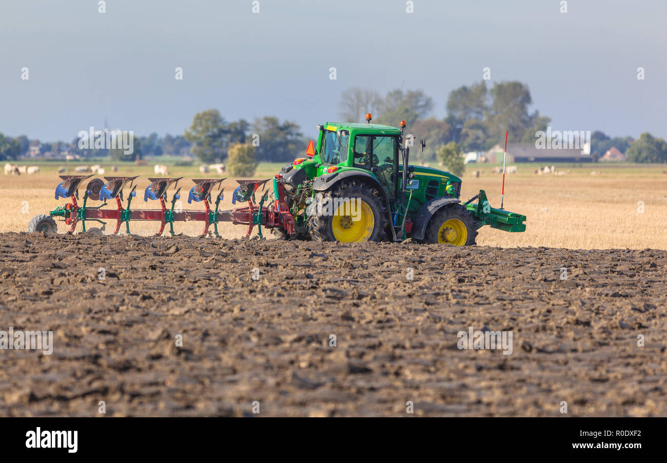 Farming in the Netherlands, Tractor with Plough in a Field with Farm