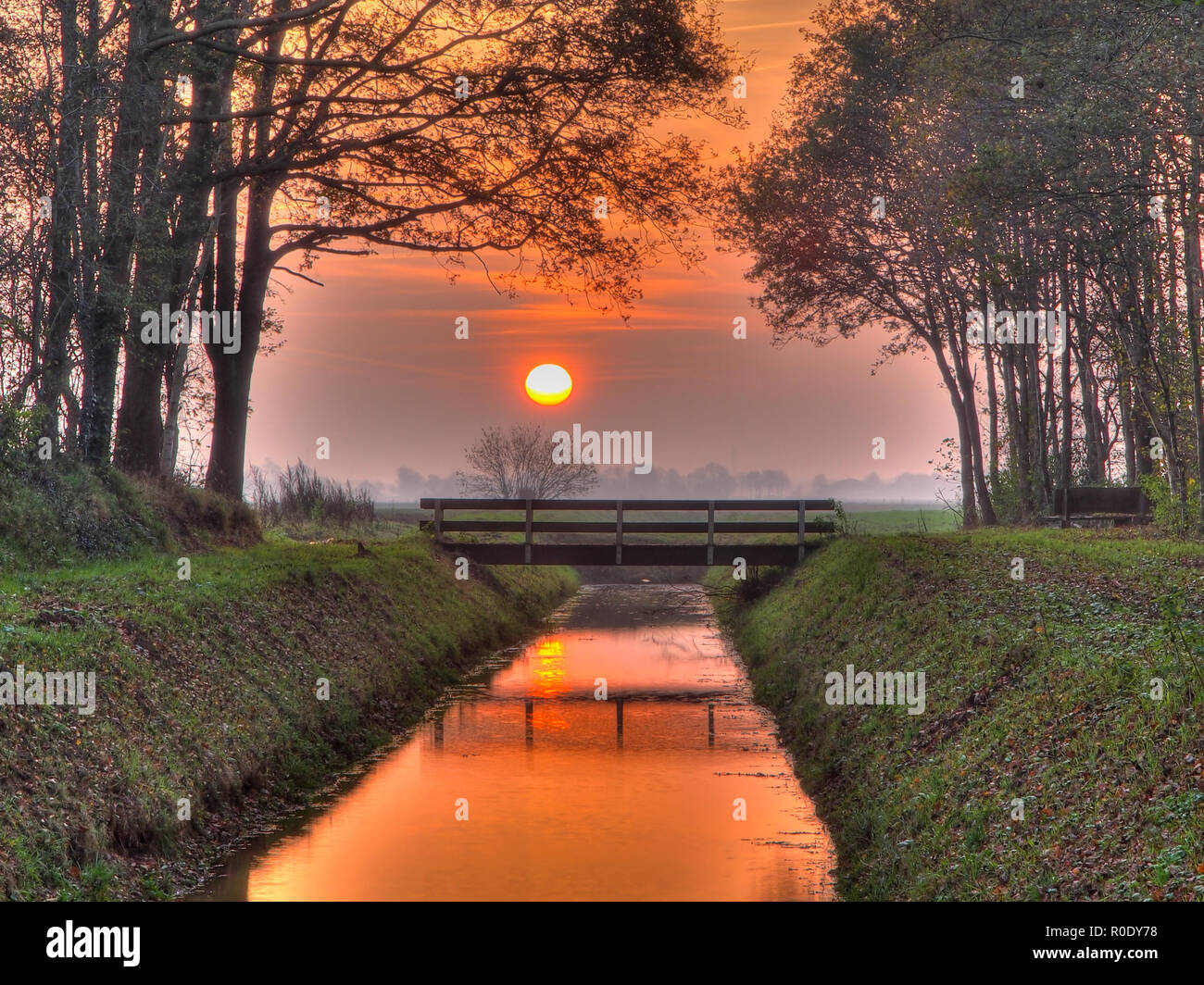 Sunset over bridge and ditch in a park Stock Photo