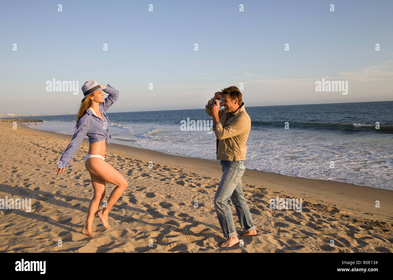 Man Taking Photo of Woman on Beach II Stock Photo