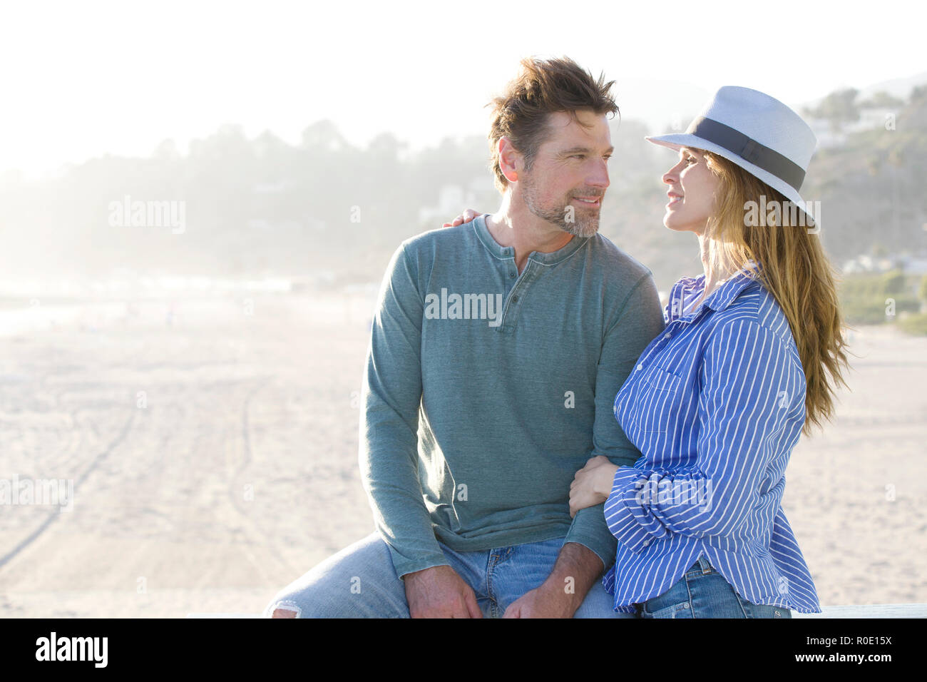 Half-Length Portrait of Mid-Adult Couple Gazing at Each Other at Beach Stock Photo