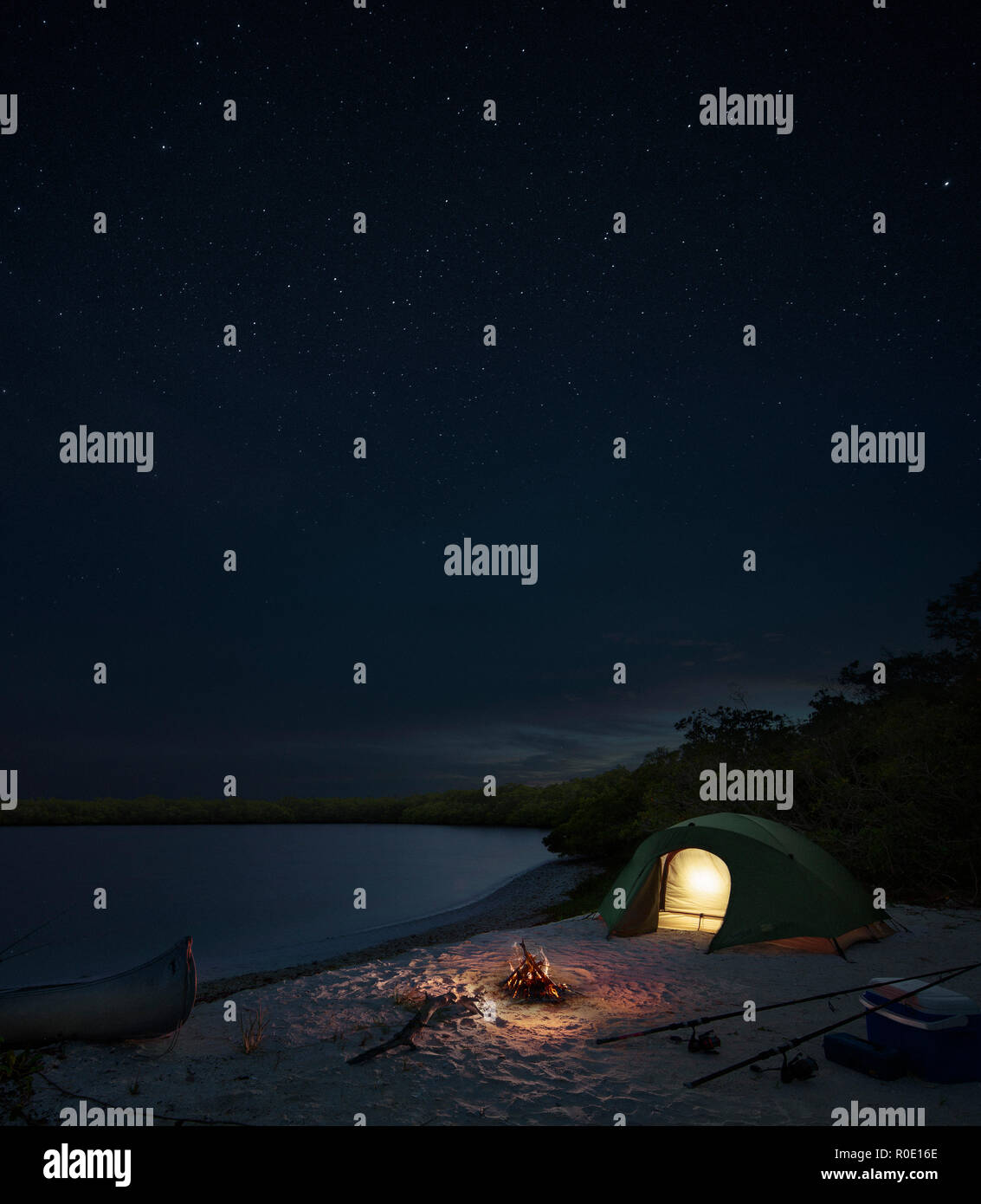 Tent and Campfire on Tropical Island at Night Stock Photo