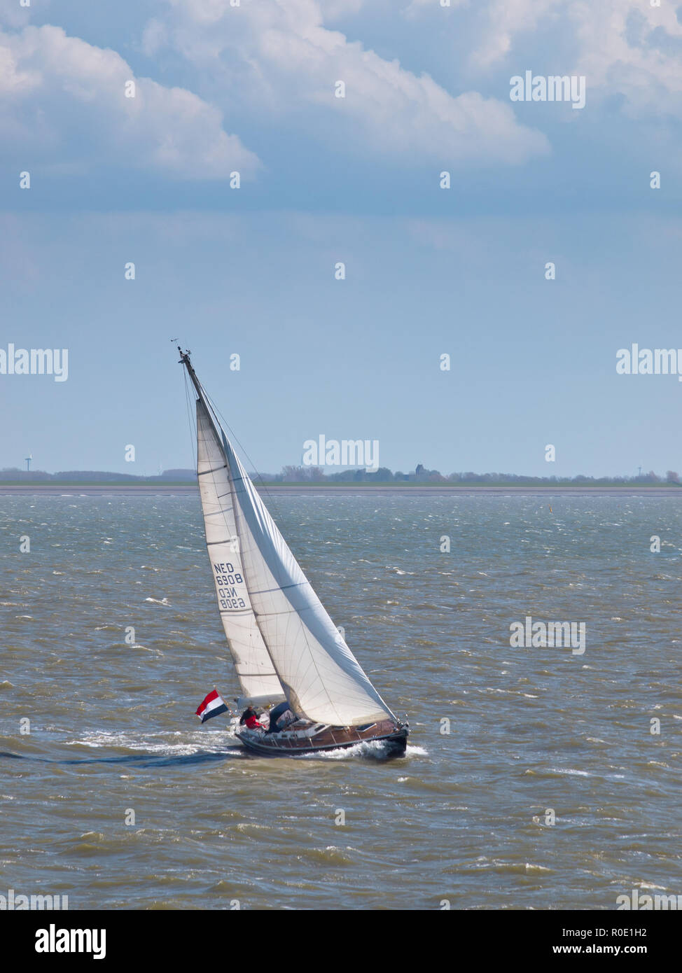 Een zeilboot vaart op de waddenzee met harde wind Stock Photo
